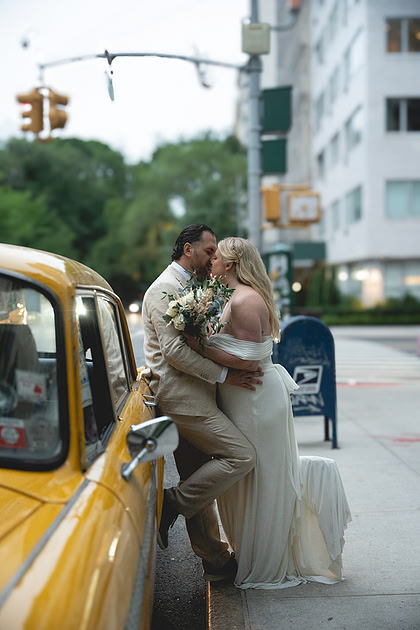 Kiss by a vintage yellow cab, unmistakably New York