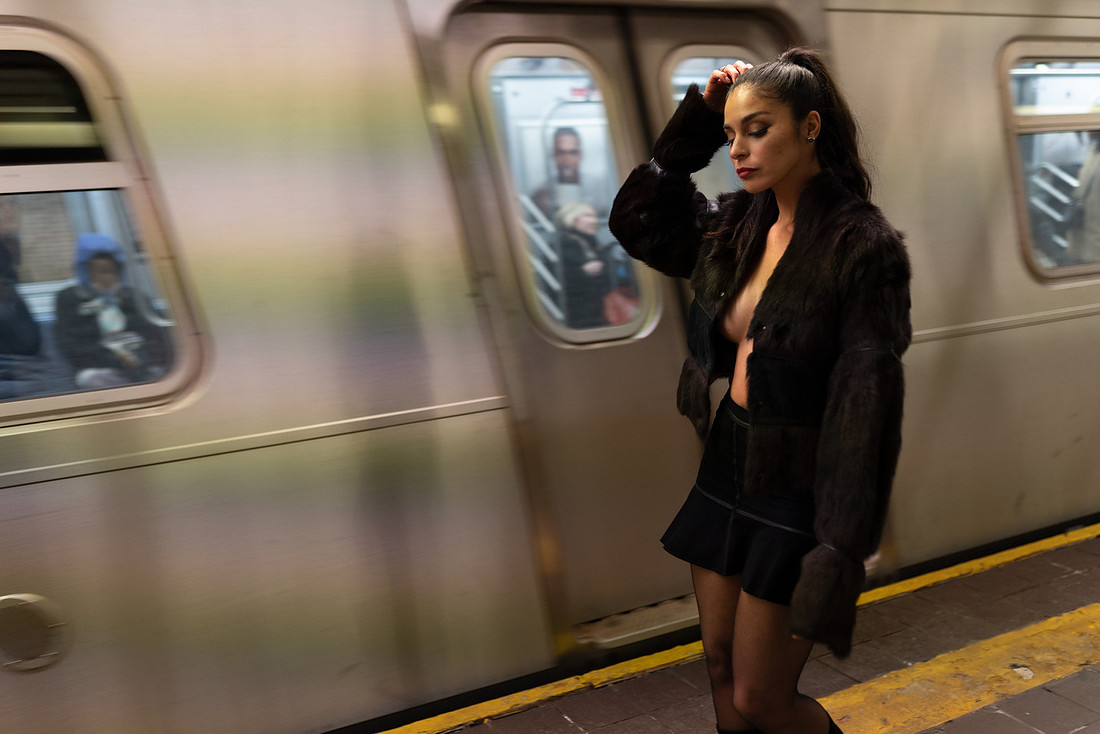 Marisol Sollyluna pausing near a column; cool fluorescent light, subway signs in frame.